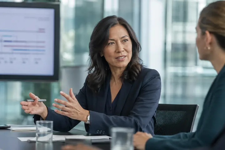 Senior clinical research leader guiding a strategic discussion in a modern biotechnology workplace
